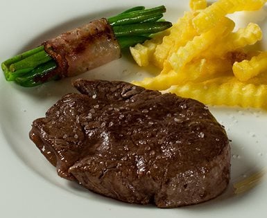 Fleisch mit Fisolen und Pommes Frites auf Teller