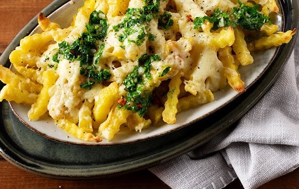 Mit Käse überbackene Cheese Fries auf Teller