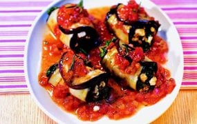 Gefüllte Melanzaniröllchen auf Tomatengemüse